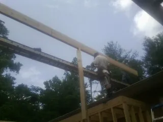 Carpenter setting a ridge beam over a new addition frame — Ice Dam Removal by Roofing Brothers in Niwot