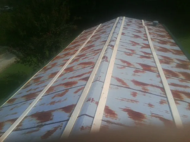 Rusted metal roof panels with new wood purlins before replacement — Storm Damage Roof Repair in Niwot by Roofing Brothers