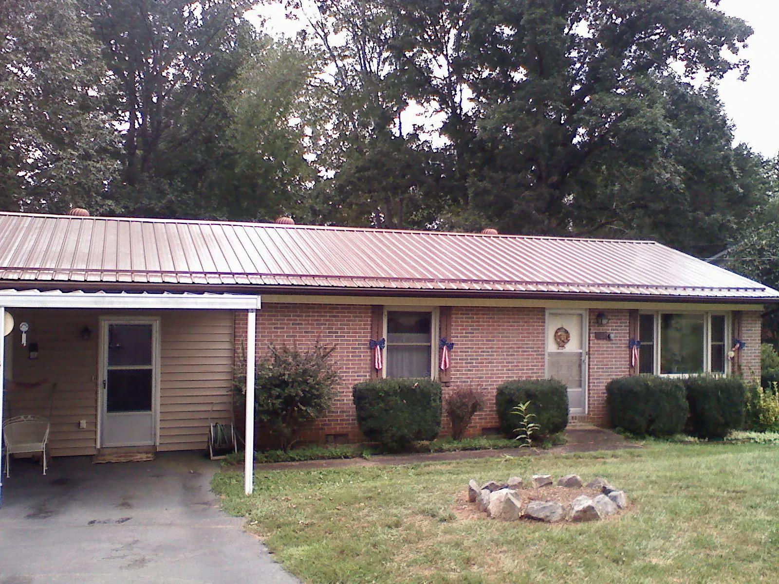 Bronze metal roof and carport on a brick ranch home — Roof Repair work by our crew in Niwot